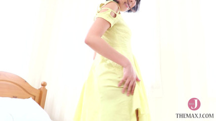 大人のおもちゃで遊ぶ黄色いドレスを着た女の子。